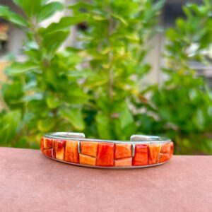 A cuff bracelet made of coral and silver.