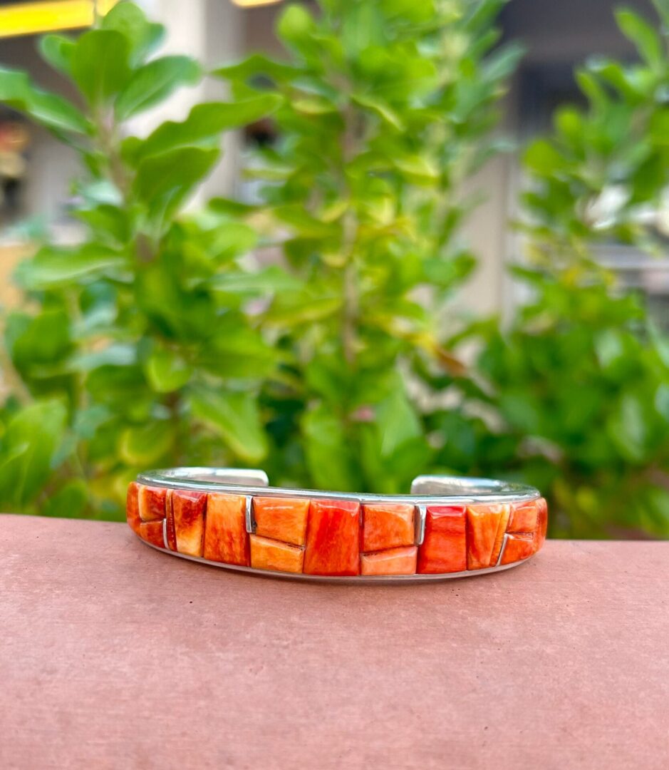 A cuff bracelet made of coral and silver.