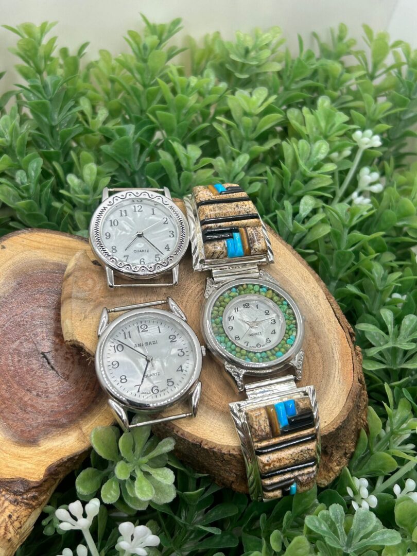 Three watches sitting on top of a piece of wood.