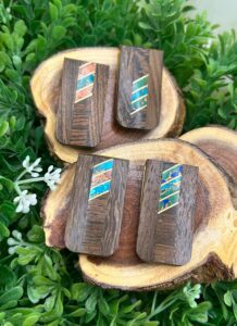 Three wooden cufflinks on top of a piece of wood.