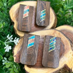 Three wooden cufflinks on top of a piece of wood.