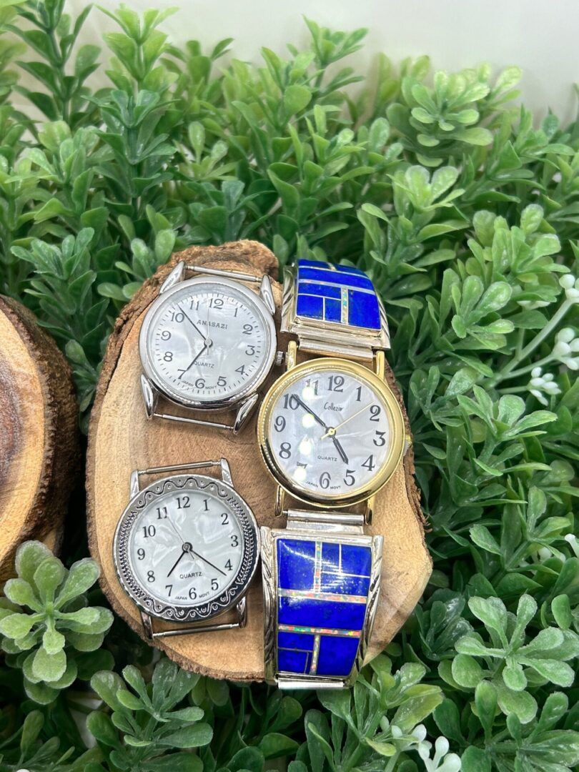 Three watches sitting on a piece of wood.