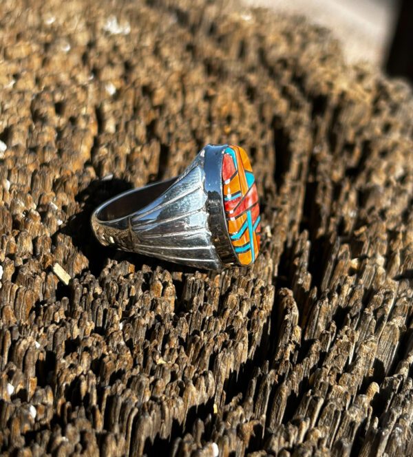 A silver ring with colorful stone inlay.