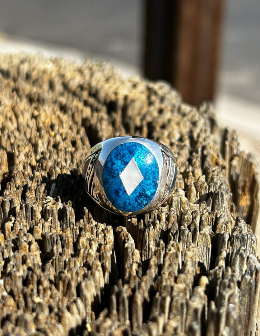 A silver ring with a blue stone and white diamond.