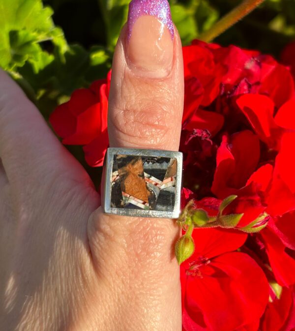 A silver ring with a colorful stone inlay.