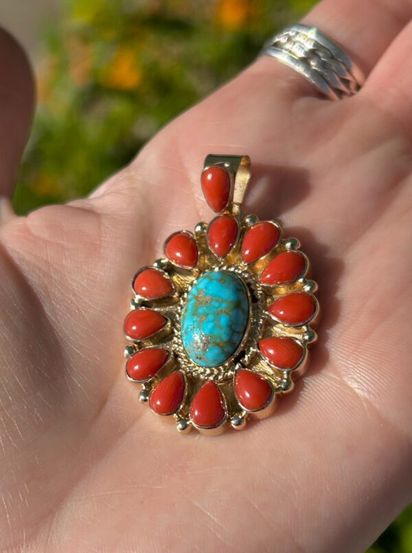 Gold pendant with turquoise and coral stones.