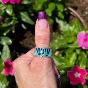 A person wearing a ring with a blue stone.