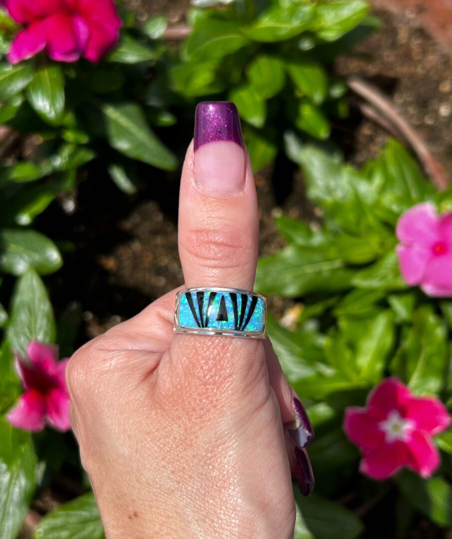 A person wearing a ring with a blue stone.