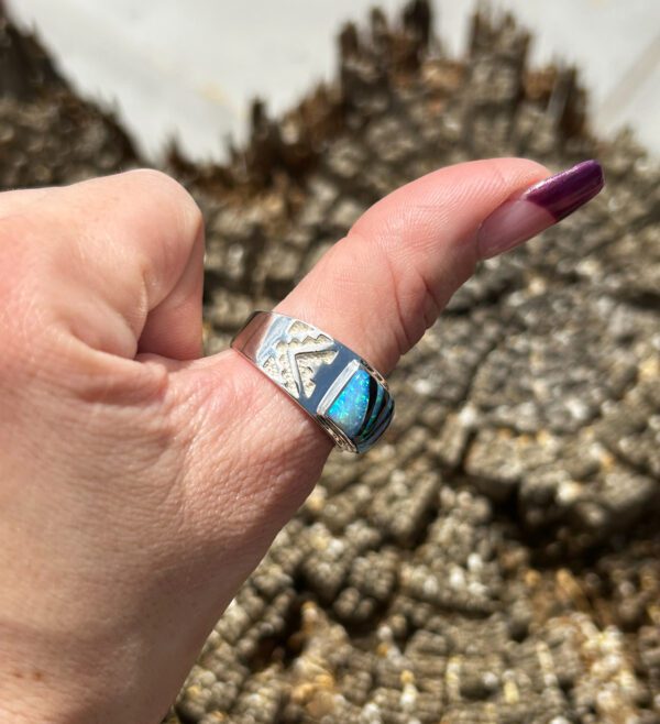 A silver ring with a blue opal stone.