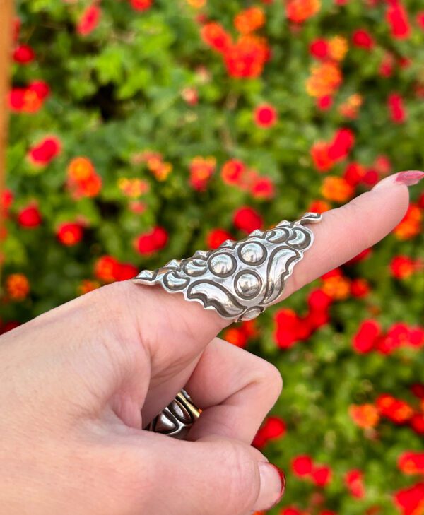 A silver ring with a floral design.