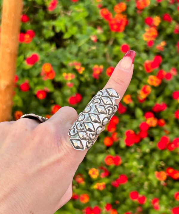 A person wearing a silver thumb ring.