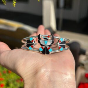 A silver bracelet with colorful inlaid stones.