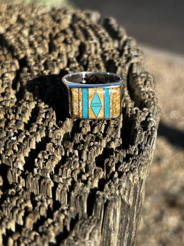 A silver ring with turquoise and brown gemstones.