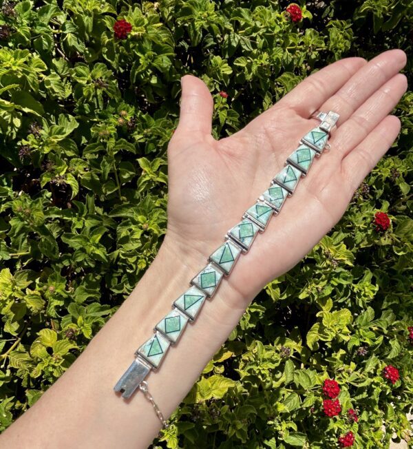 Green stone and silver bracelet on wrist.