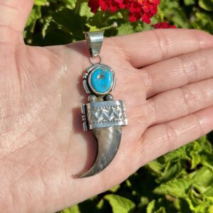 Silver bear claw pendant with turquoise stone.