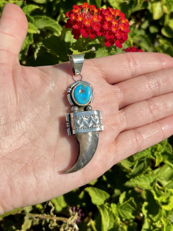 Silver bear claw pendant with turquoise stone.