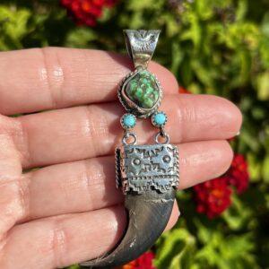 Silver bear claw pendant with turquoise stones.