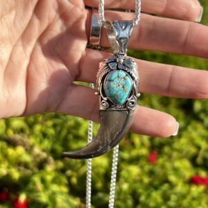 Silver claw necklace with turquoise stone.