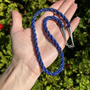 Blue lapis lazuli beaded necklace on hand.